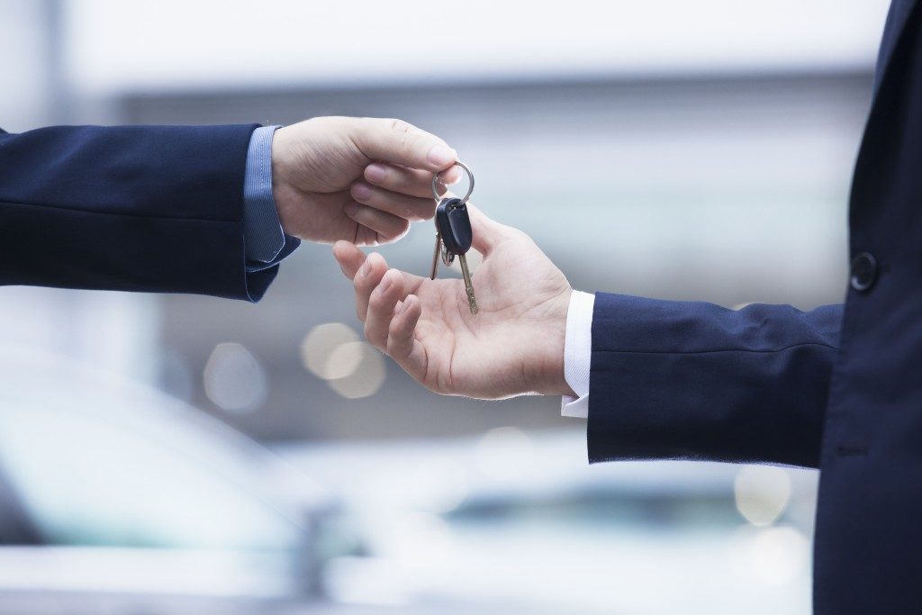 Car salesman handing over car keys