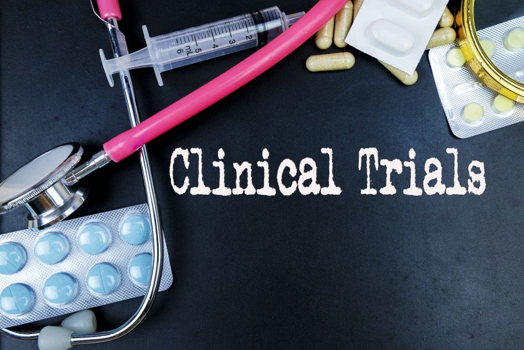 Clinical trials text with medical equipment and pills