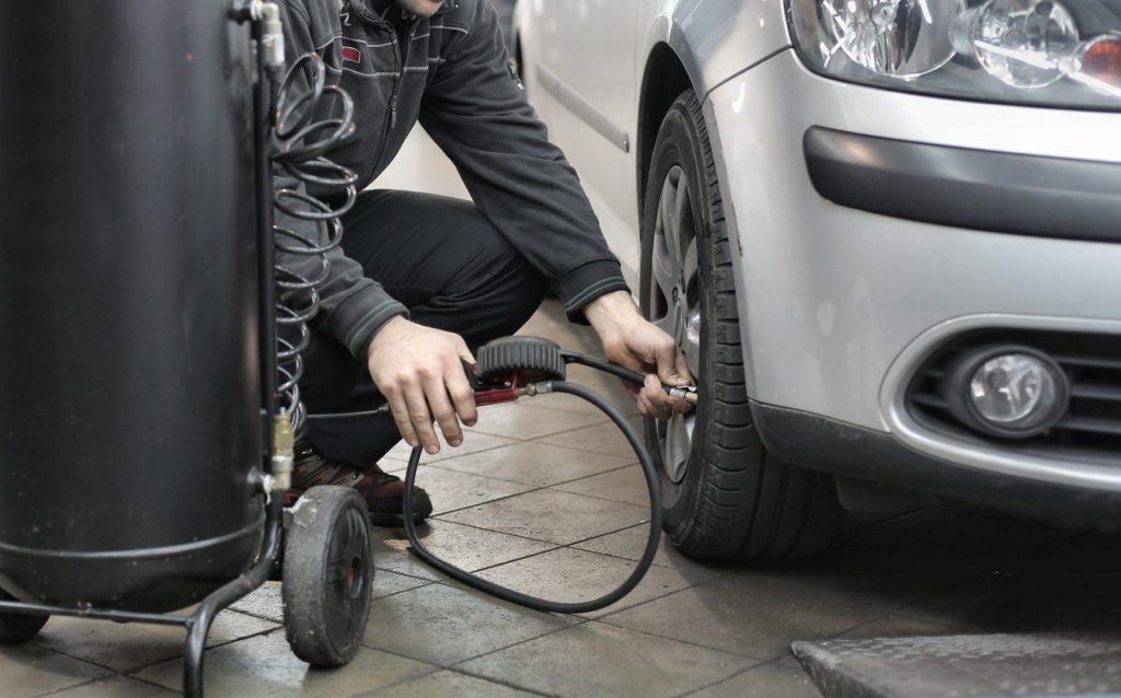 person pumping air into a car tire