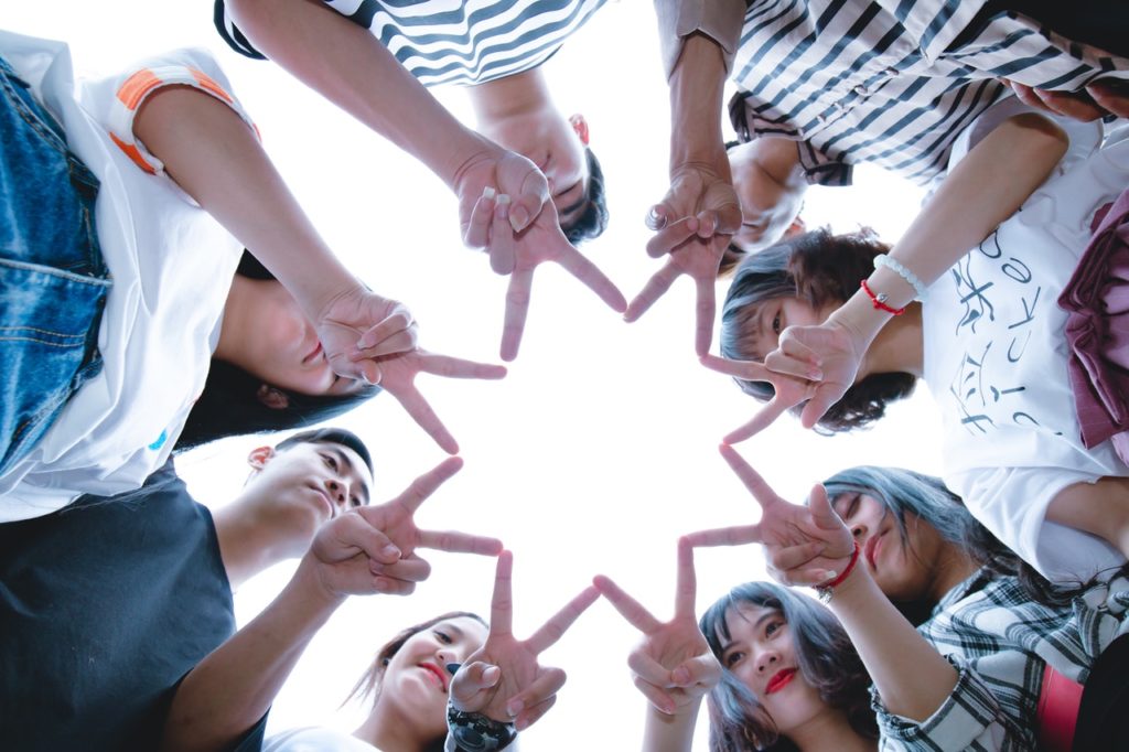 group of young people forming star with their fingers